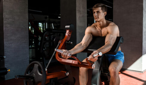 Homme musclé qui s'entraine les bras à la salle