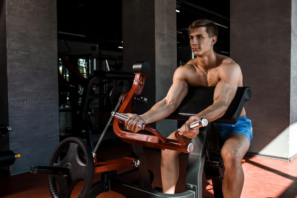 Homme musclé qui s'entraine les bras à la salle